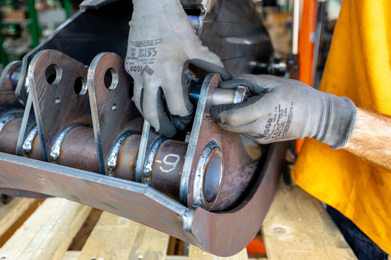 Close-up view of rusty automotive brake calipers and rotors in various states of wear and deterioration.