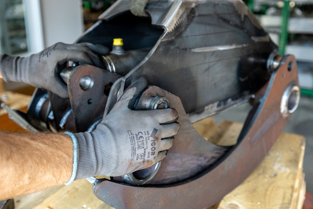 Close-up sequence showing the step-by-step process of replacing a car's brake caliper with new hardware.
