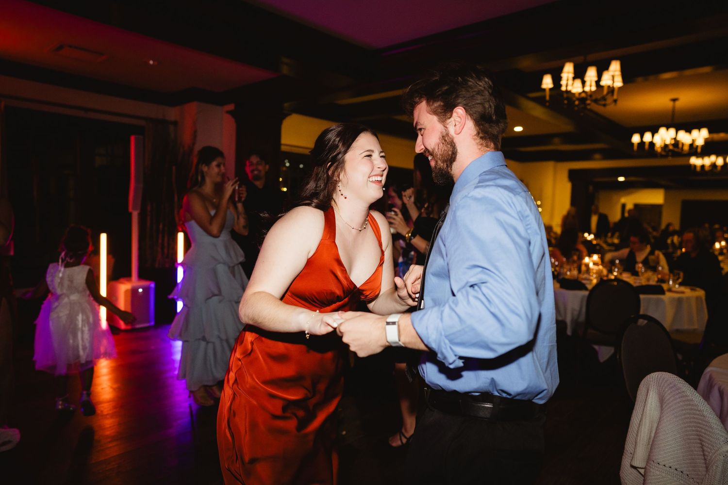 Couples dancing together at an evening reception with warm lighting and festive atmosphere.