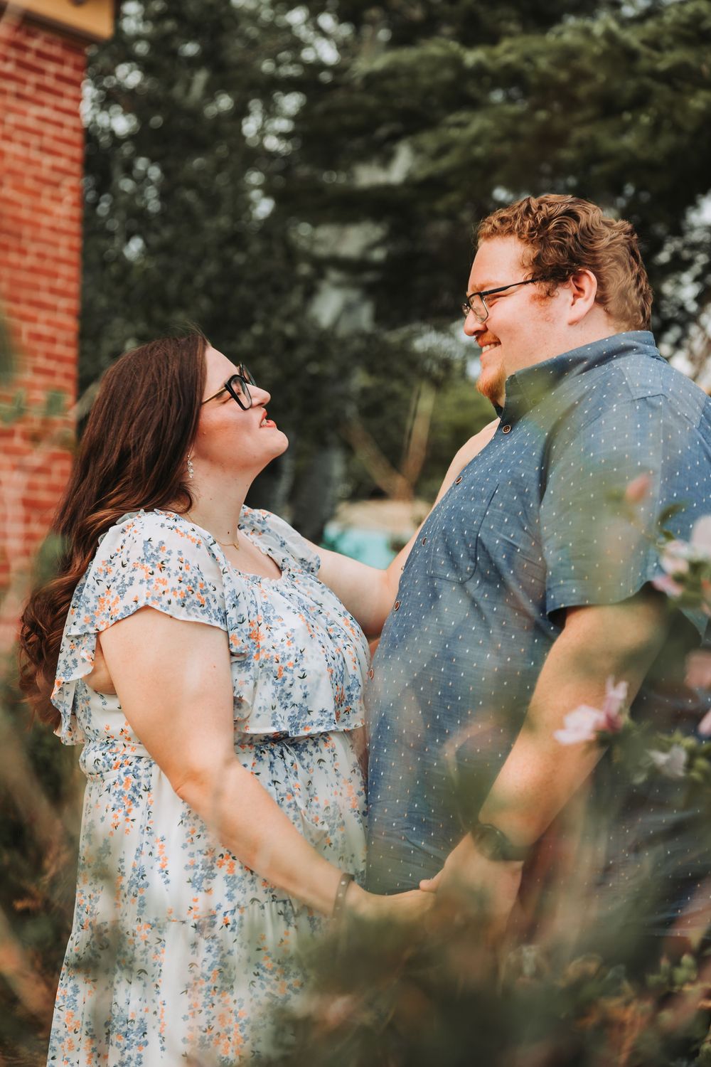 A couple in casual attire shares tender moments through a series of romantic outdoor portraits against a brick wall.