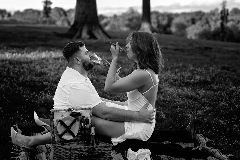 A series of romantic black and white photos showing tender moments between a couple in an outdoor setting.