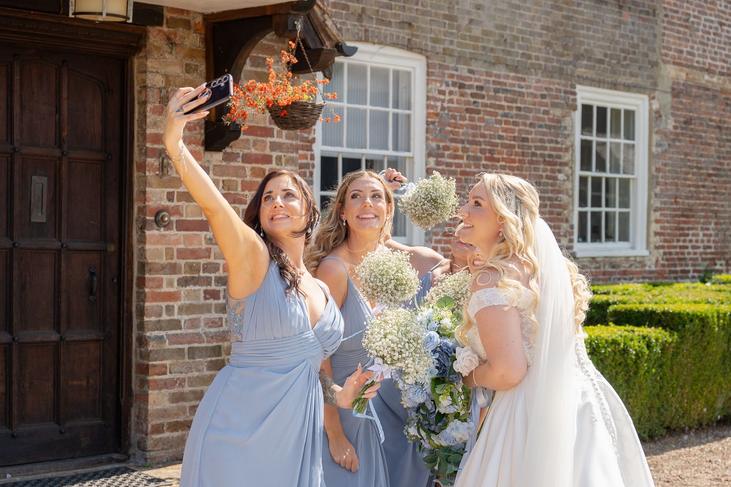 Bride and bridesmaids posing for a selfie in front of Solton Manor, relaxed and natural wedding photography with SHOT by JFK