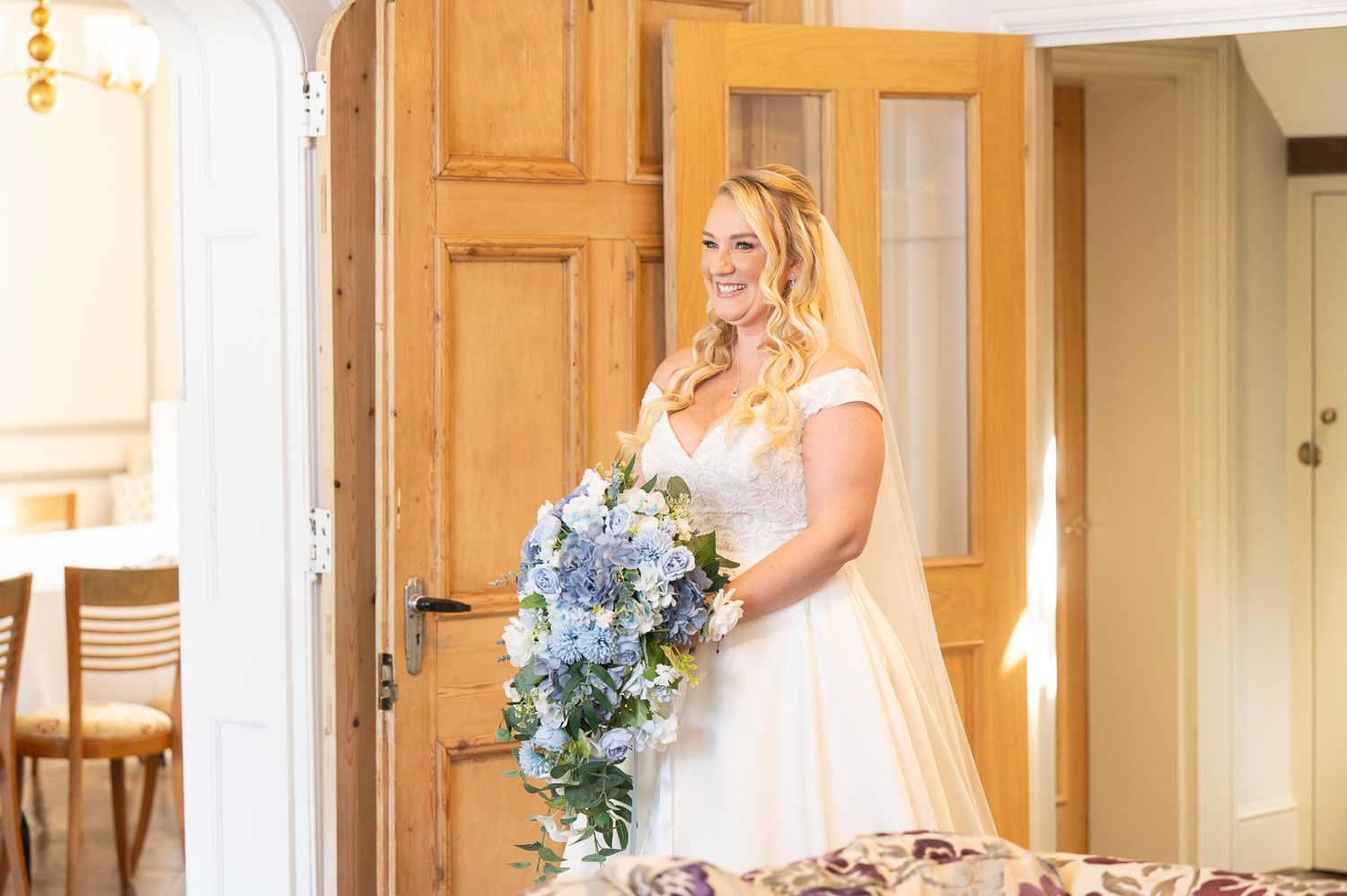 Bride smiling at bridesmaids during dress reveal at Solton Manor, Kent wedding photography by SHOT by JFK.