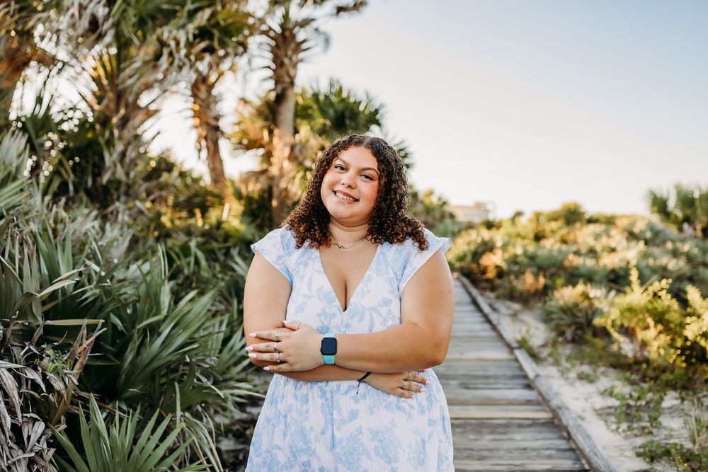 A series of beach portraits in a light blue floral dress against a backdrop of sand dunes and coastal vegetation.