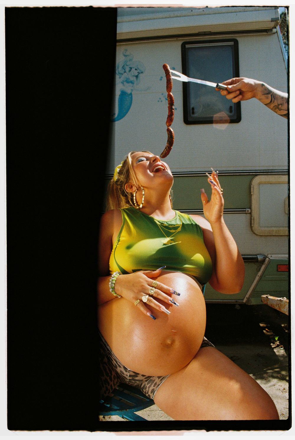 A series of four artistic photographs showing a pregnant woman's belly against a dark background.