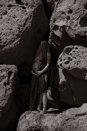 Black and white photograph of rocky cliffs with dramatic shadows and textures.