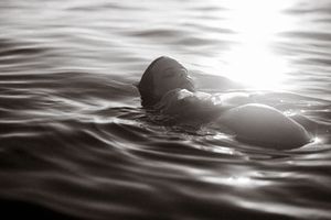 Abstract black and white photography of rippling water surface with dramatic lighting.