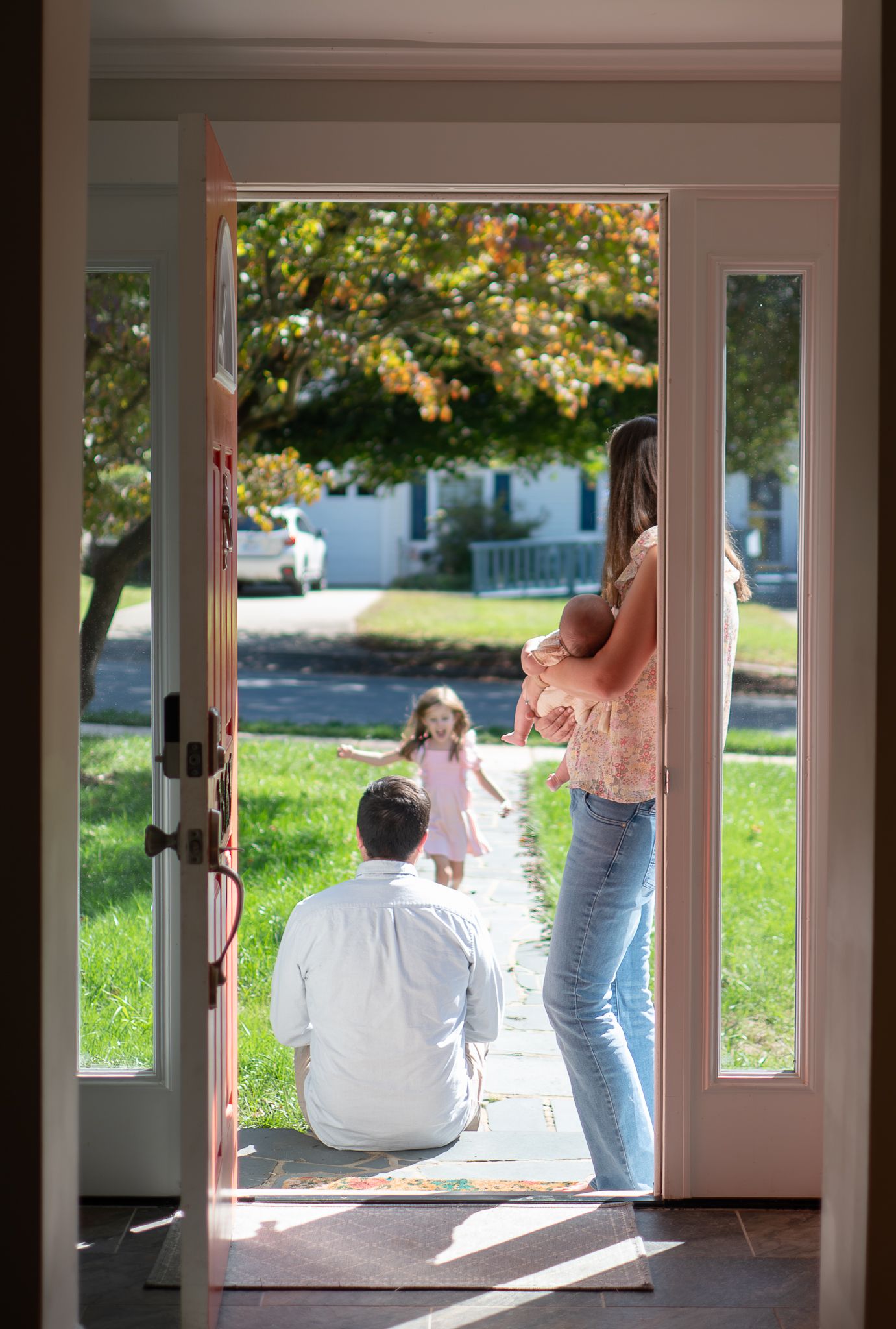 A series of four candid photos showing tender moments between parent and baby by a sunlit window.