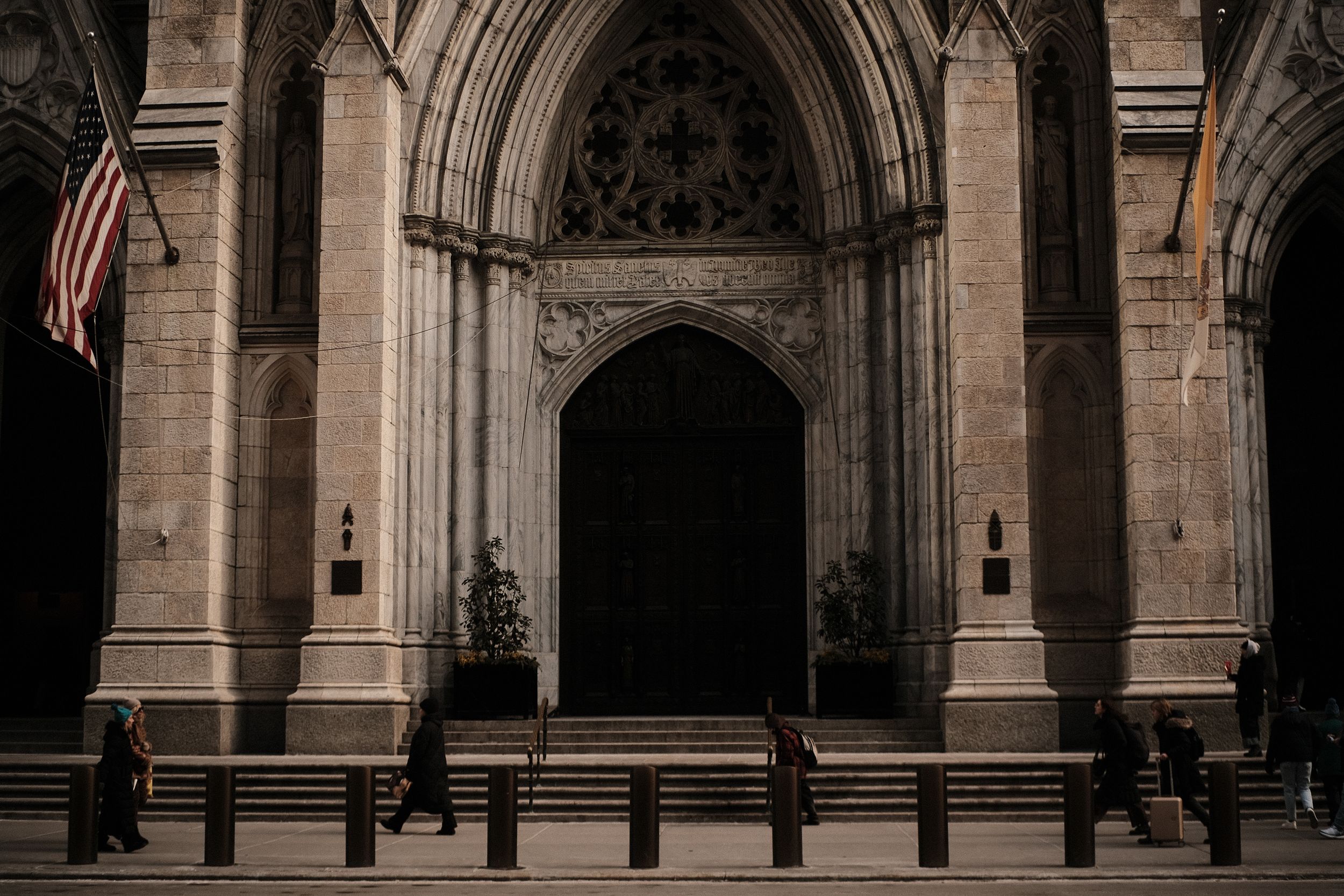 Historic stone archway with American flag and gothic architectural details.