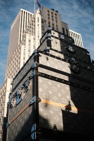 Large Louis Vuitton branded construction barrier in front of tall building.