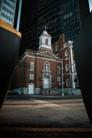 Historic brick church with white trim and spires photographed from a low angle.
