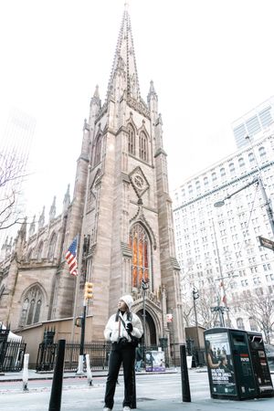 Gothic cathedral spires of St. Patrick's Cathedral rise against urban backdrop in winter.