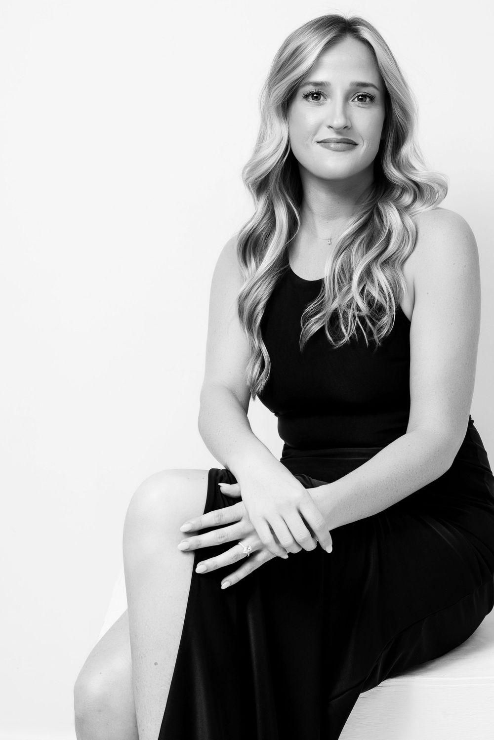 Black and white studio portrait of a young woman in an elegant black dress sitting on a chair, Nashville portrait photographer