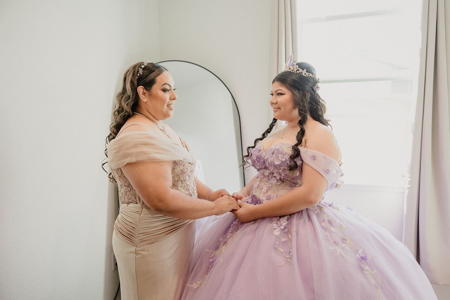 A stunning lavender ball gown being fitted and adjusted in a bridal preparation room.