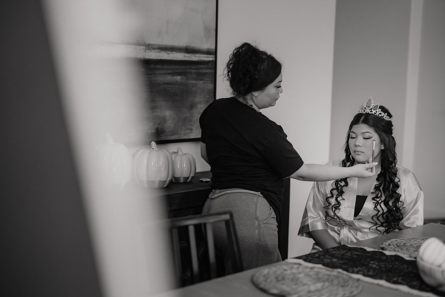 Black and white photo series showing wedding preparation moments in an indoor setting.
