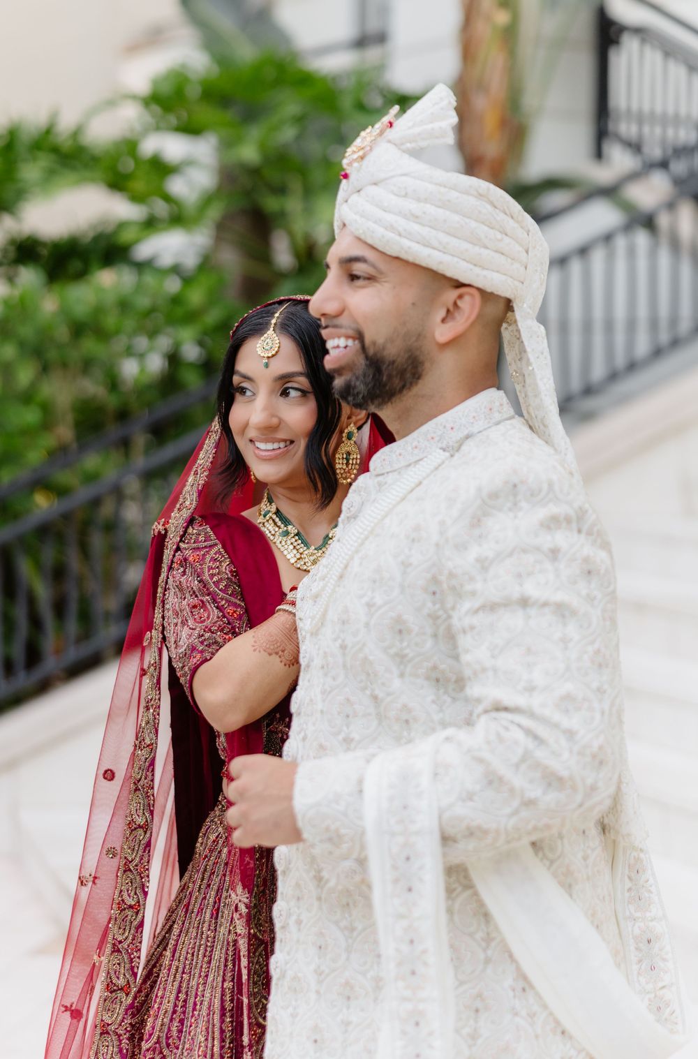 A couple in traditional South Asian wedding attire share intimate moments in a series of romantic outdoor portraits.