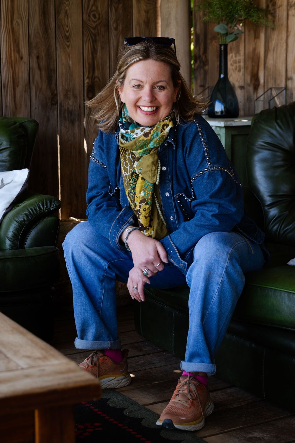 Natural headshot portrait for Kent business owner in natural setting, seated in green