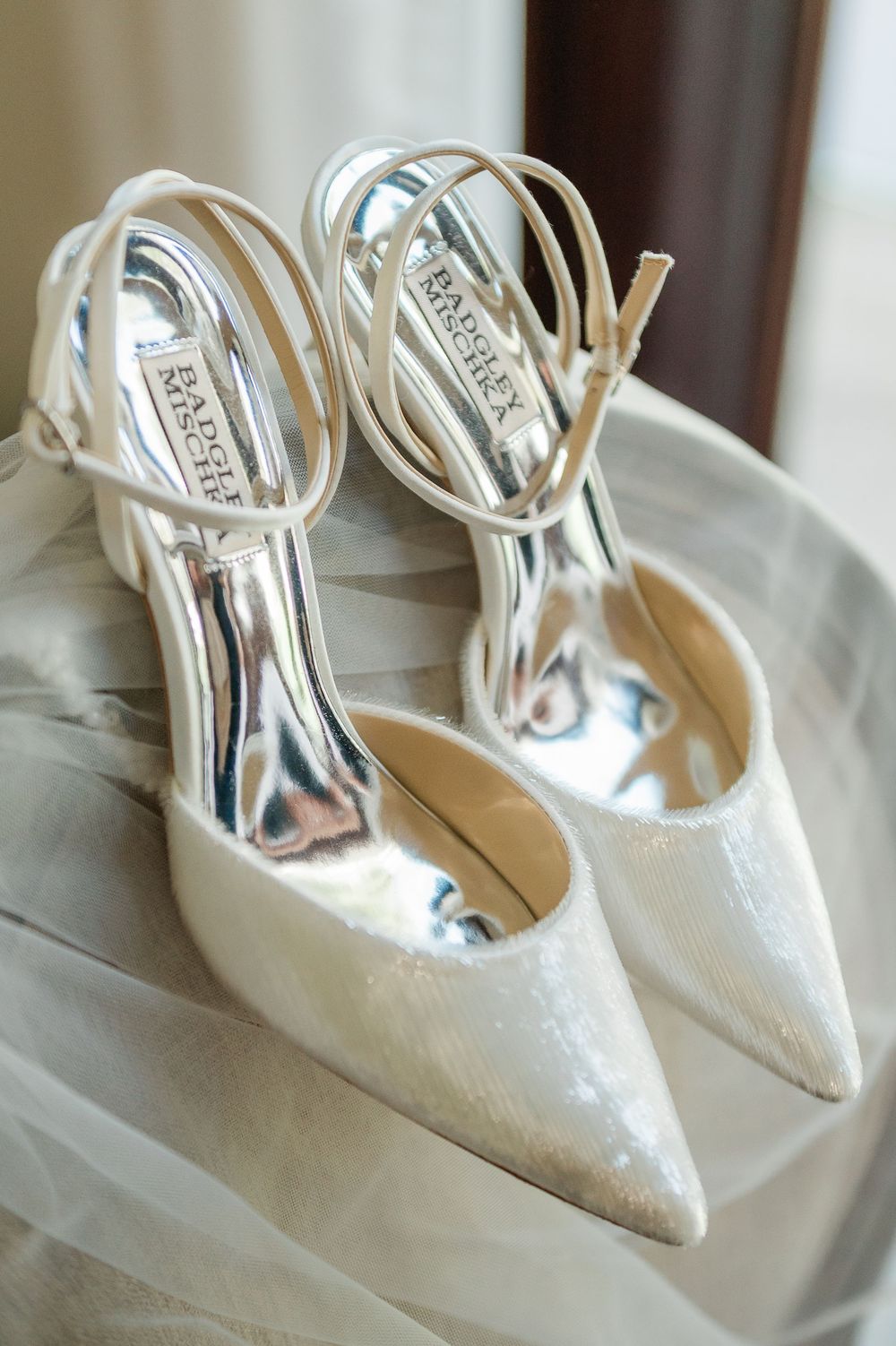 Elegant white sparkly bridal shoes lined up in a row on display.