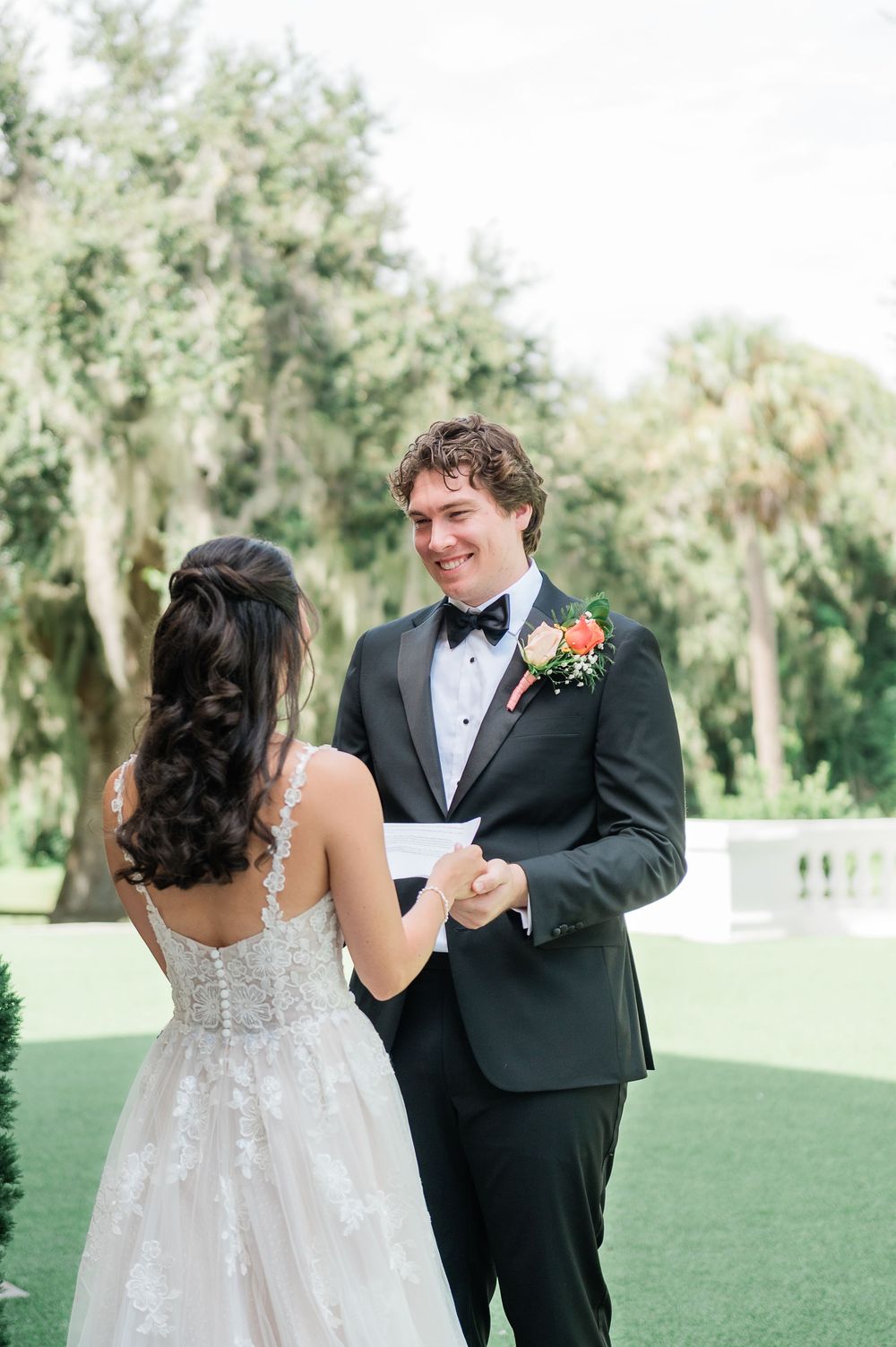 Candid wedding couple sharing a joyful moment outdoors on their special day.