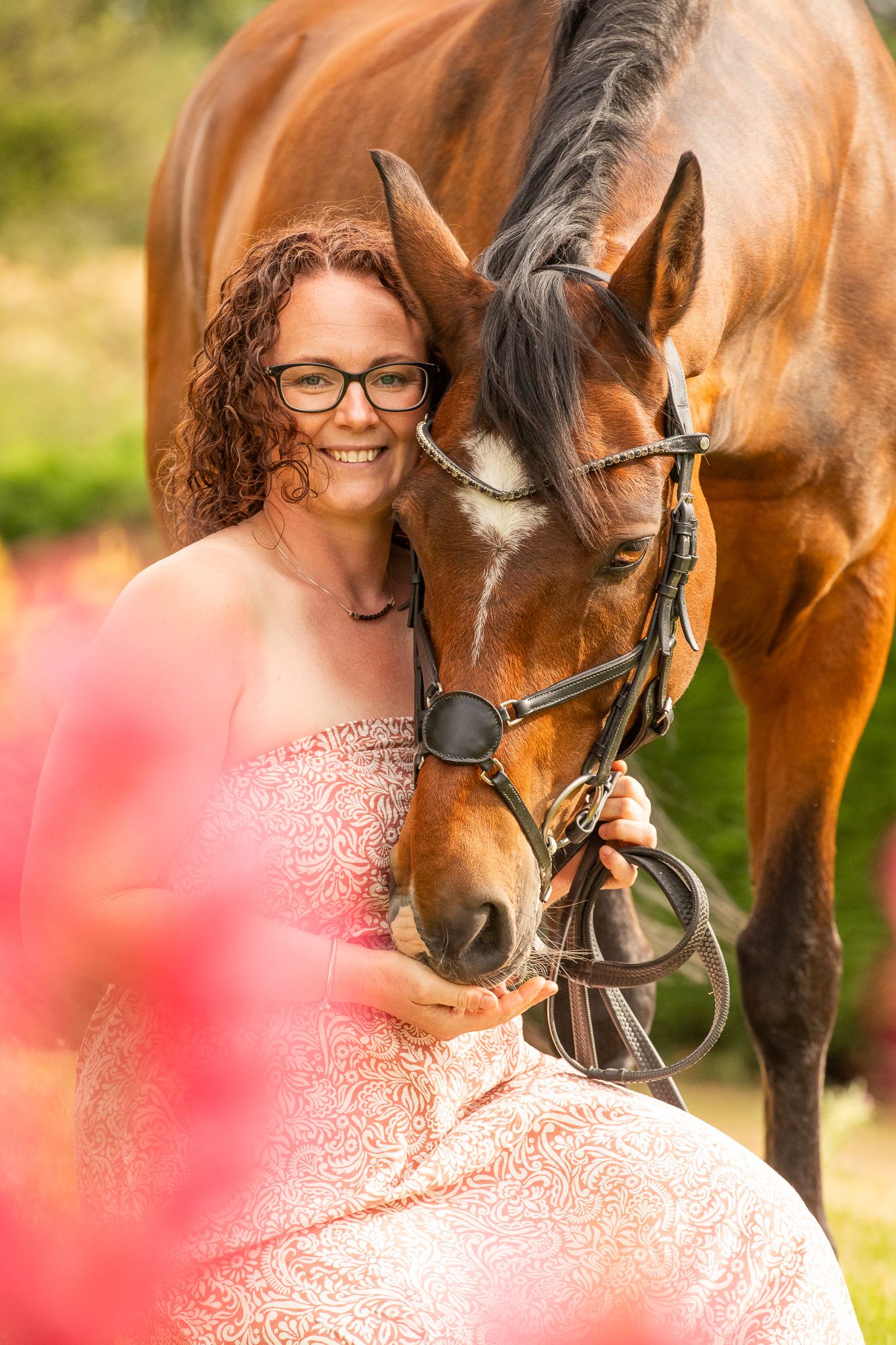 Young girl in denim overalls embraces a palomino horse in a sun-dappled forest setting.