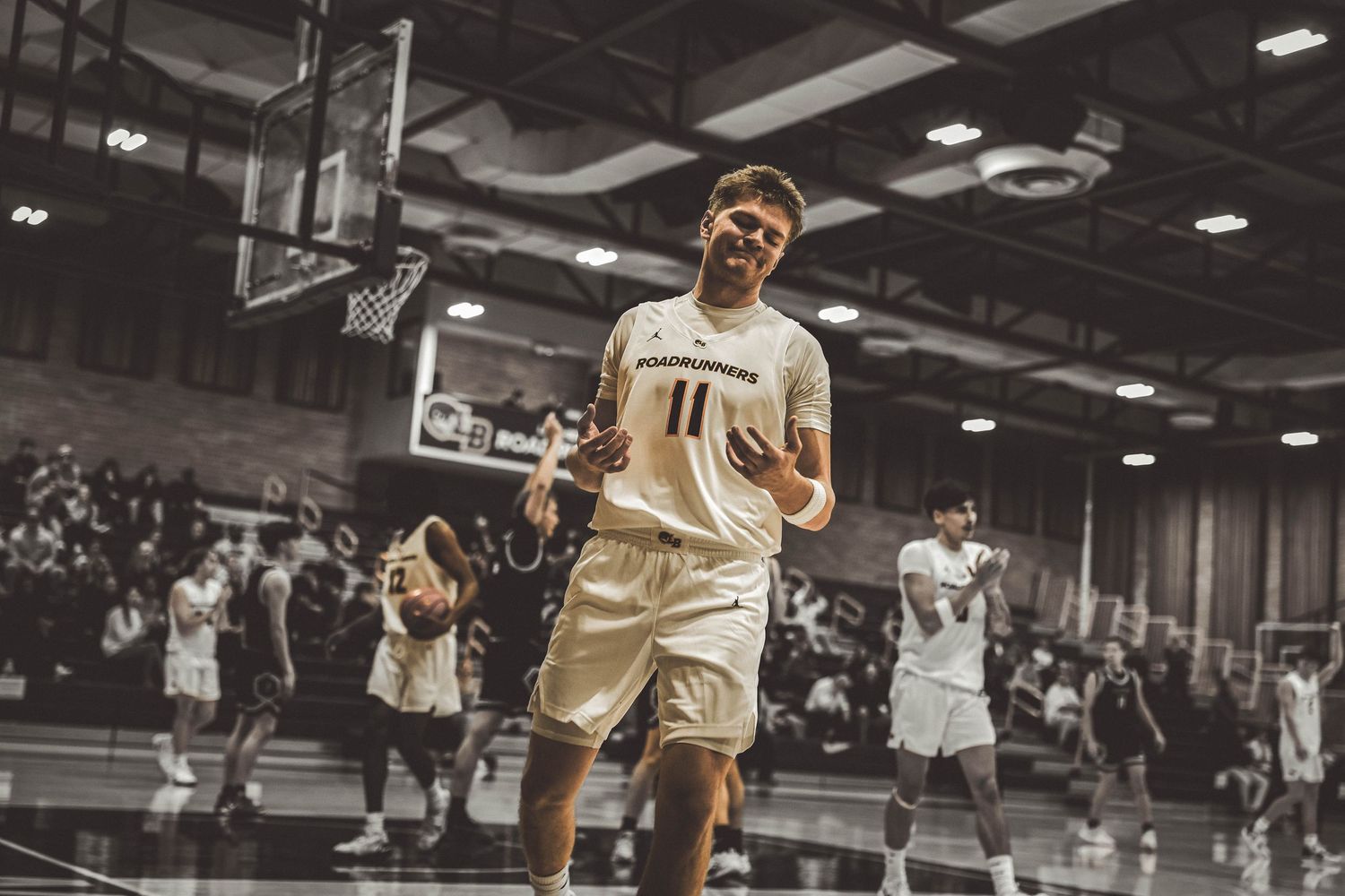 Basketball action shot showing players jumping and competing for the ball during a game.