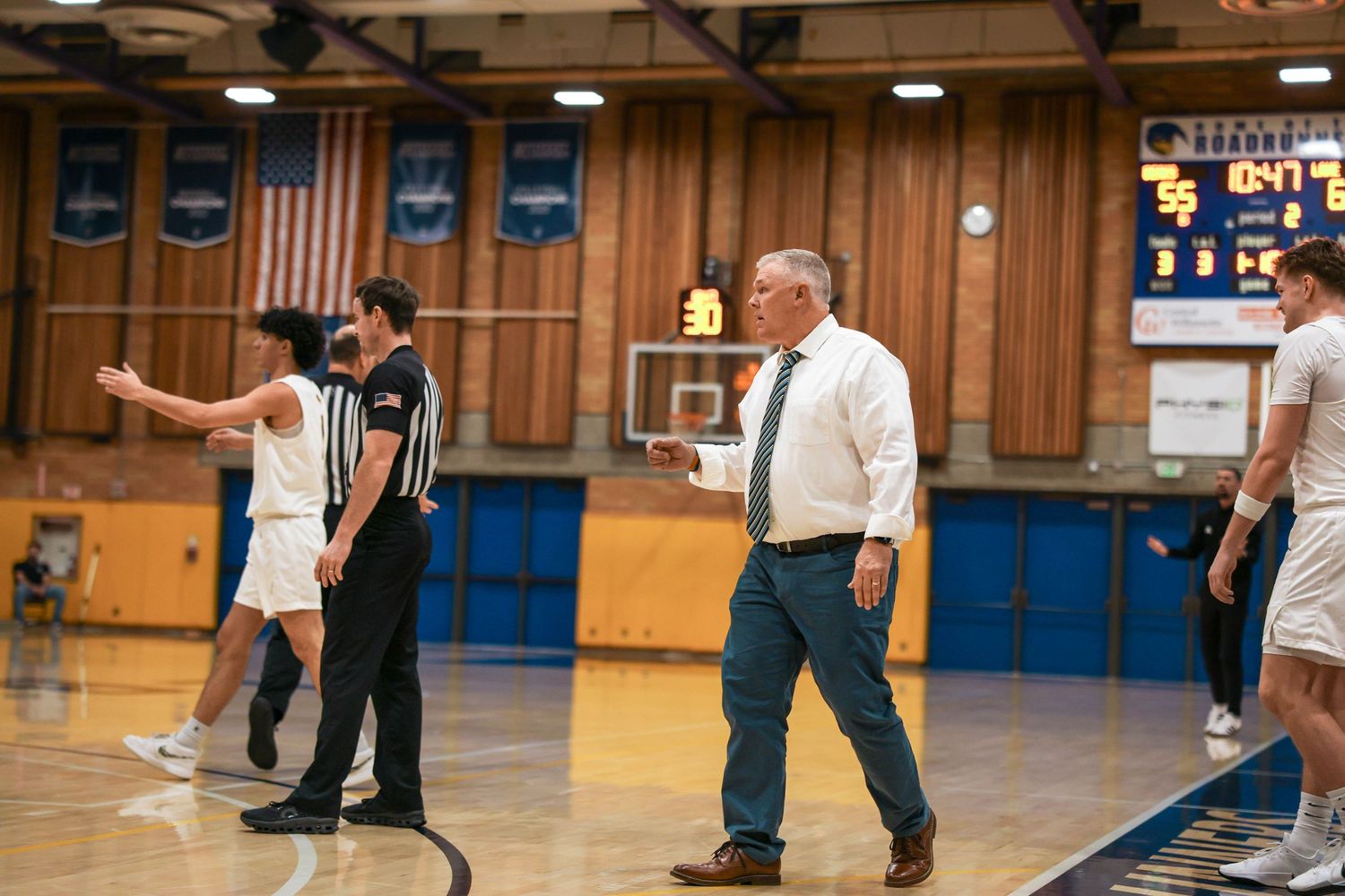 Basketball action shot showing players competing on a gymnasium court.