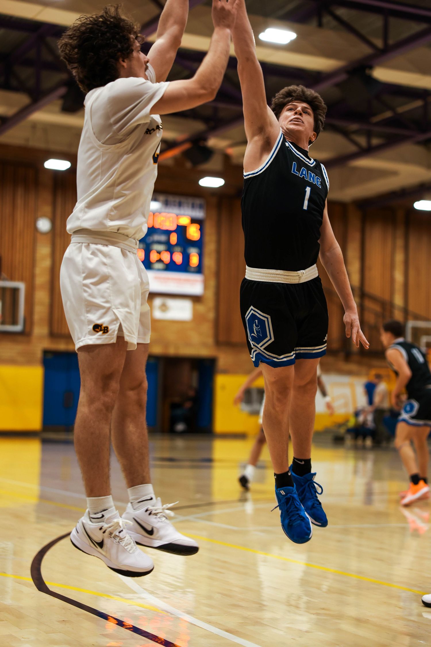 Close-up view of basketball players' legs and feet jumping during game action on wooden court.