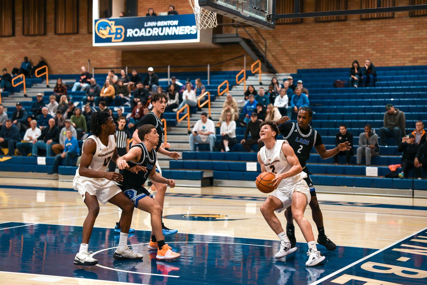 Basketball players position themselves during an offensive play on the court.