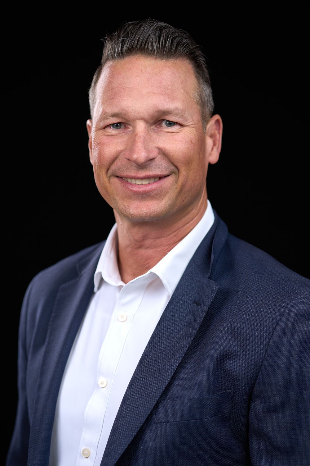 Professional headshots of a person in a navy suit and white shirt against a dark background.