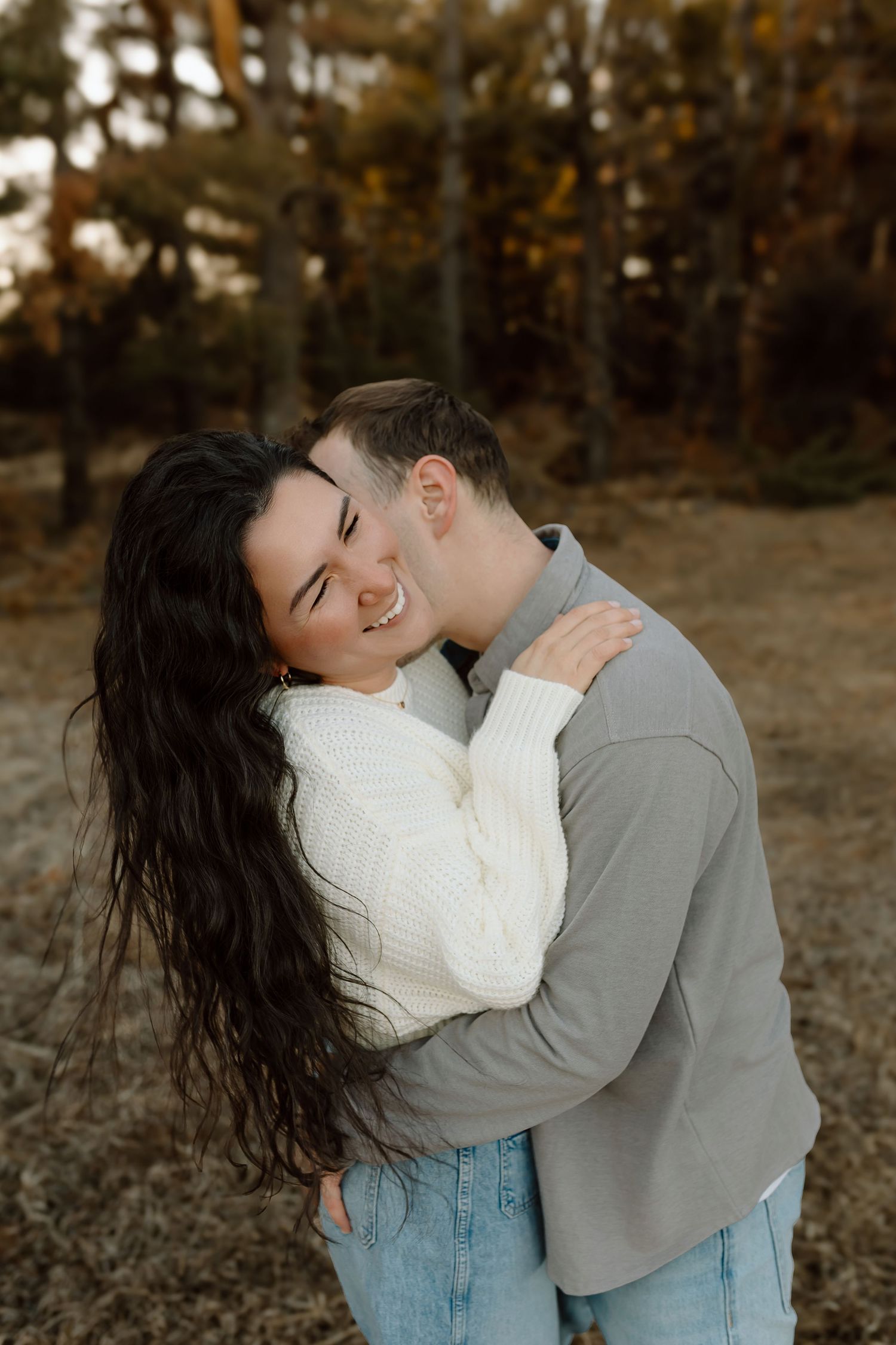 Four heartwarming candid photos show tender embraces between family members sitting together on dried grass outdoors.