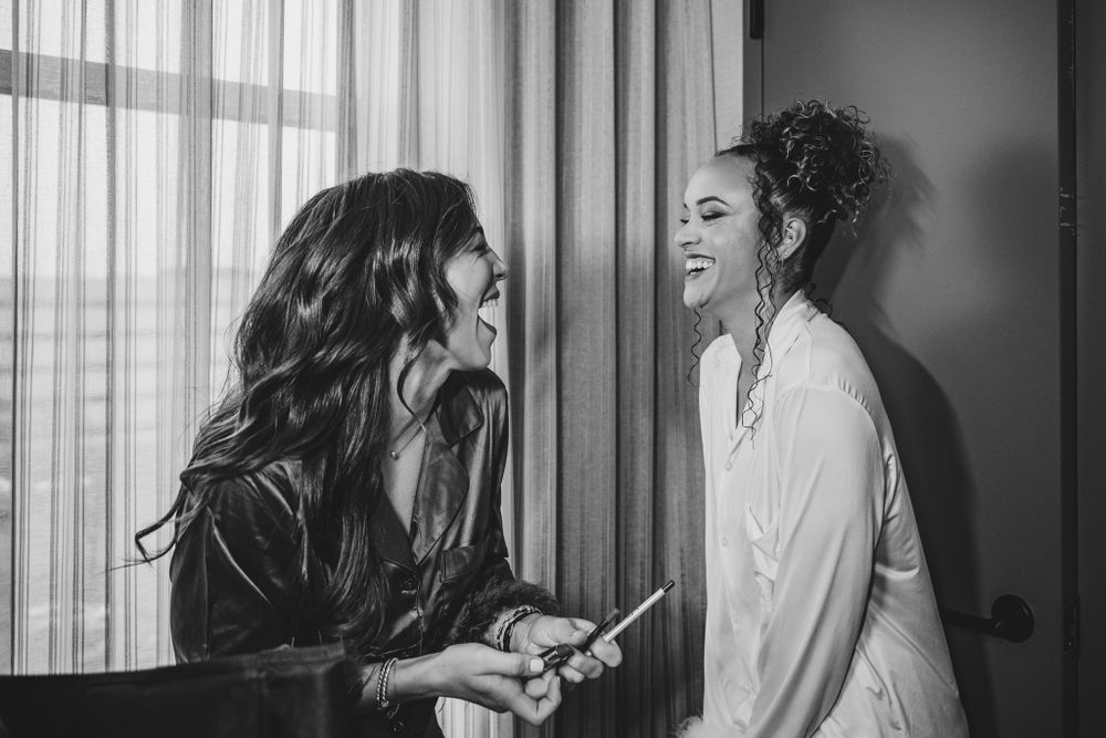 Wedding preparation scene in hotel room with soft window lighting.