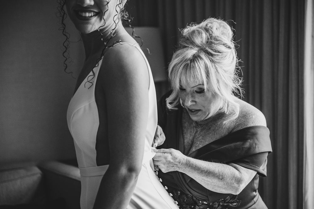 Emotional candid moments captured during wedding day preparations in hotel room.