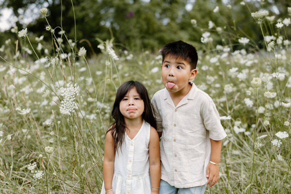 A family enjoying a tender moment together in a blooming wildflower meadow on a sunny day.