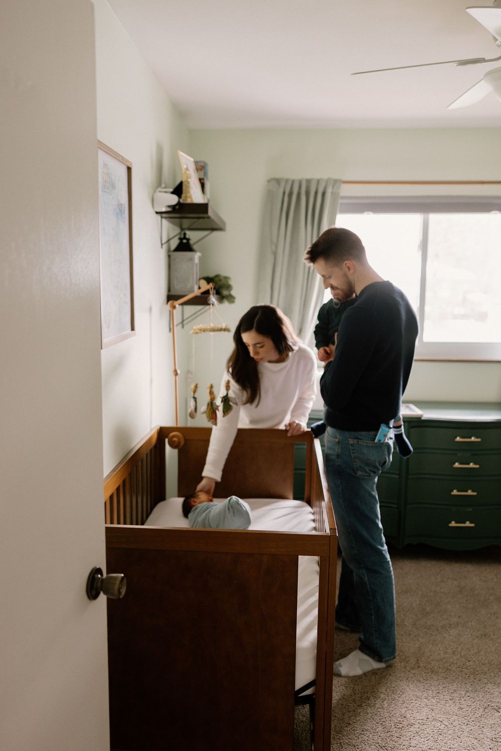 Two people in casual attire collaborate on a photography session in a bright, minimalist bedroom setting.