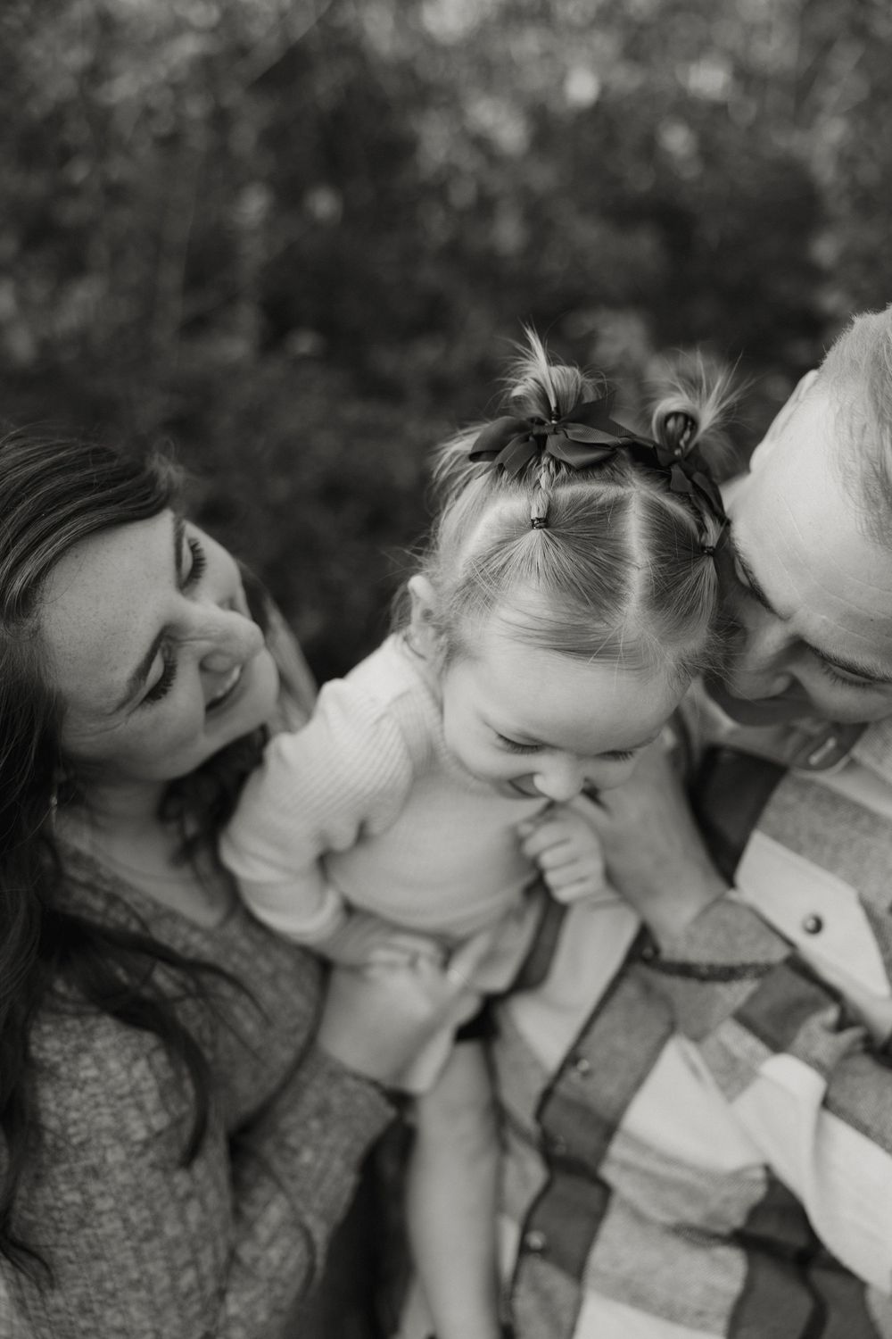 A sequence of black and white photos showing a couple sharing intimate kisses in a romantic outdoor setting.