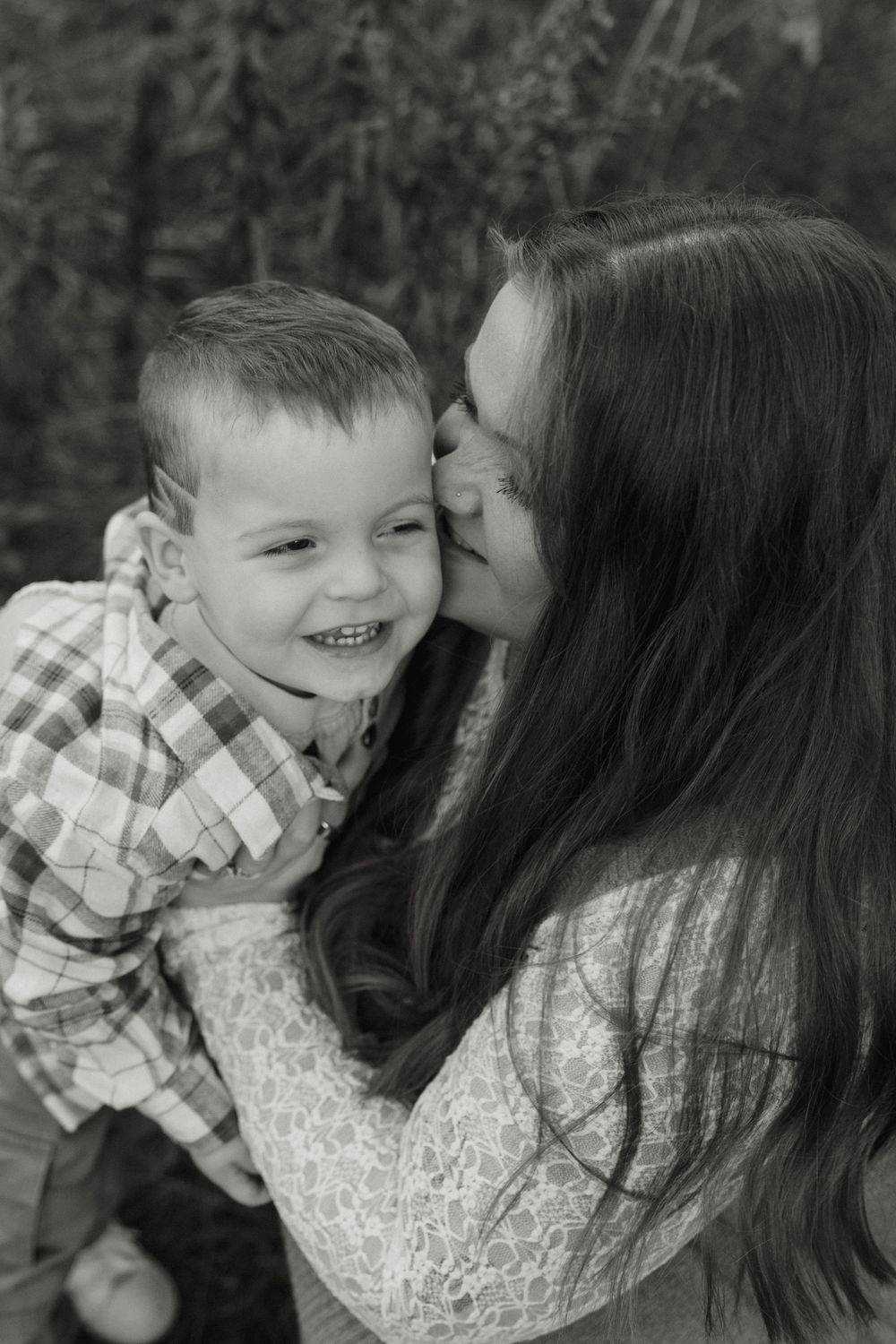 A tender black and white photo series showing a parent and child sharing affectionate moments outdoors.