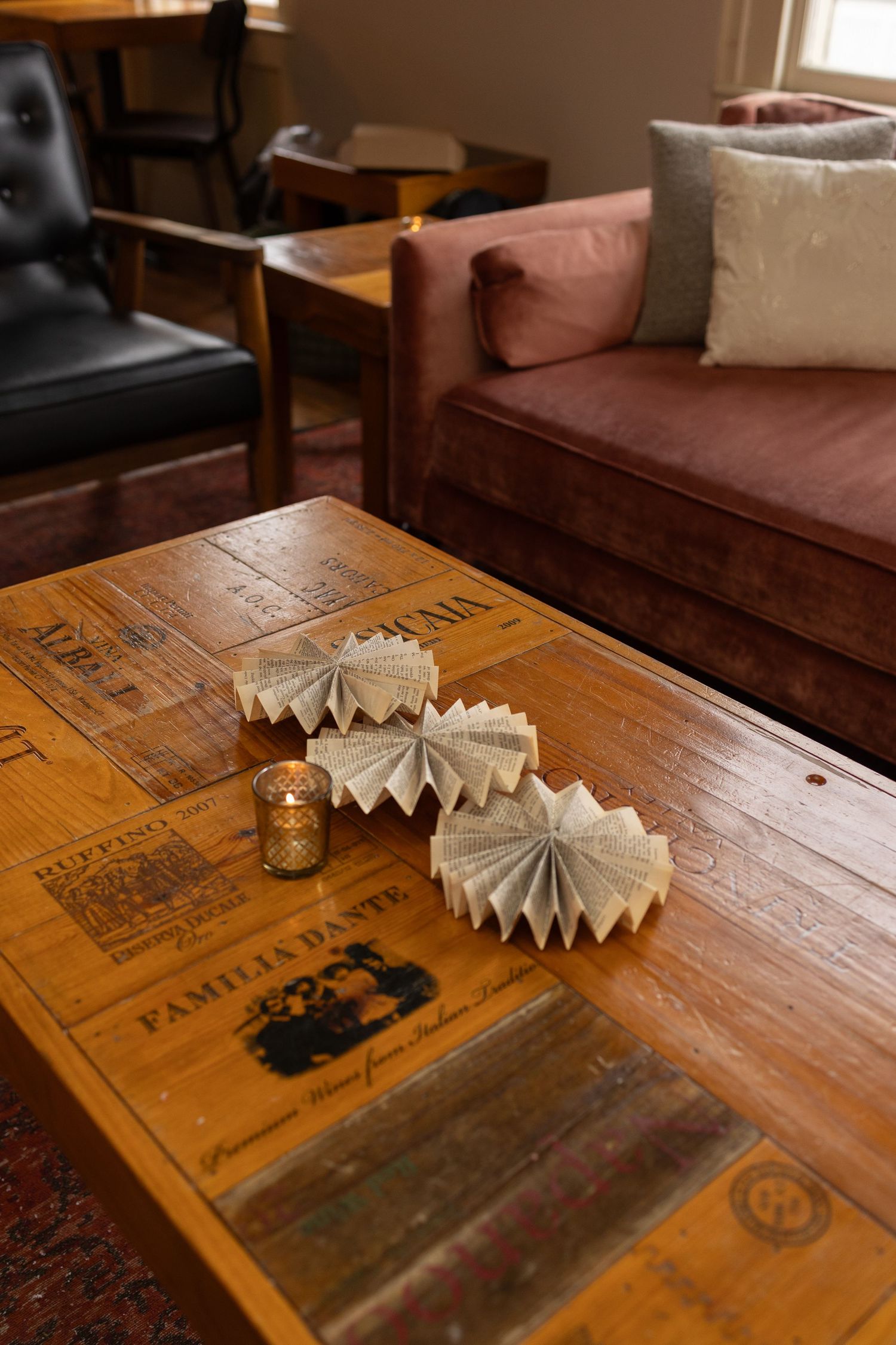 Rustic wooden table with folded paper decorations and vintage book cover details.