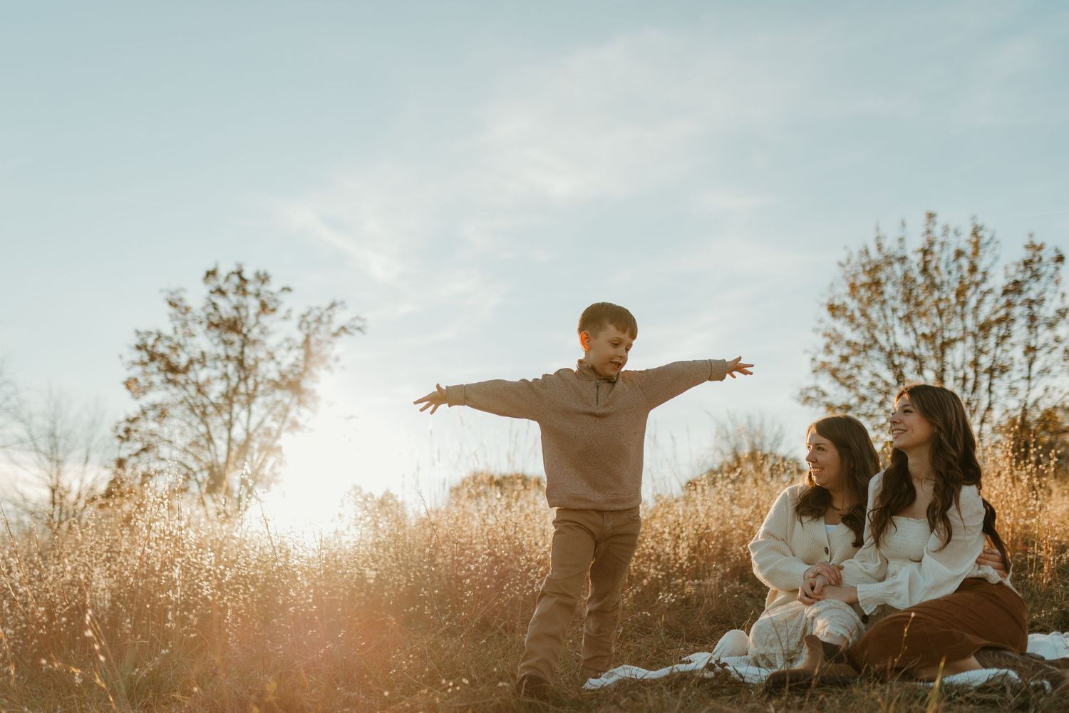 Spartanburg SC Family photographer taking photos in field while boy runs around pretending to be an airplane