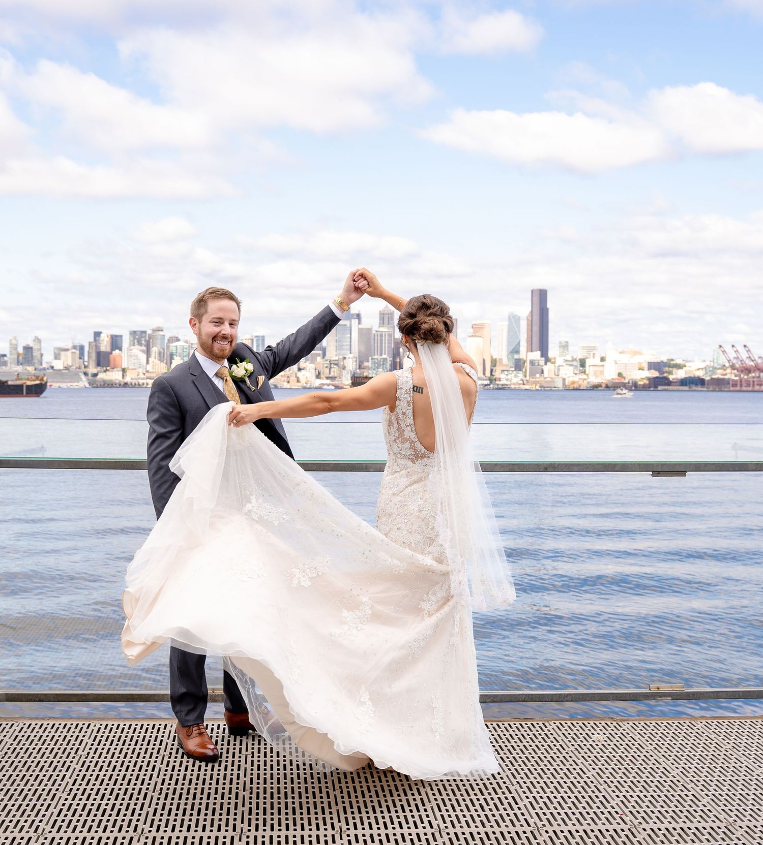 A romantic couple dancing on a pier with Seattle cityscape and waterfront view in the background.