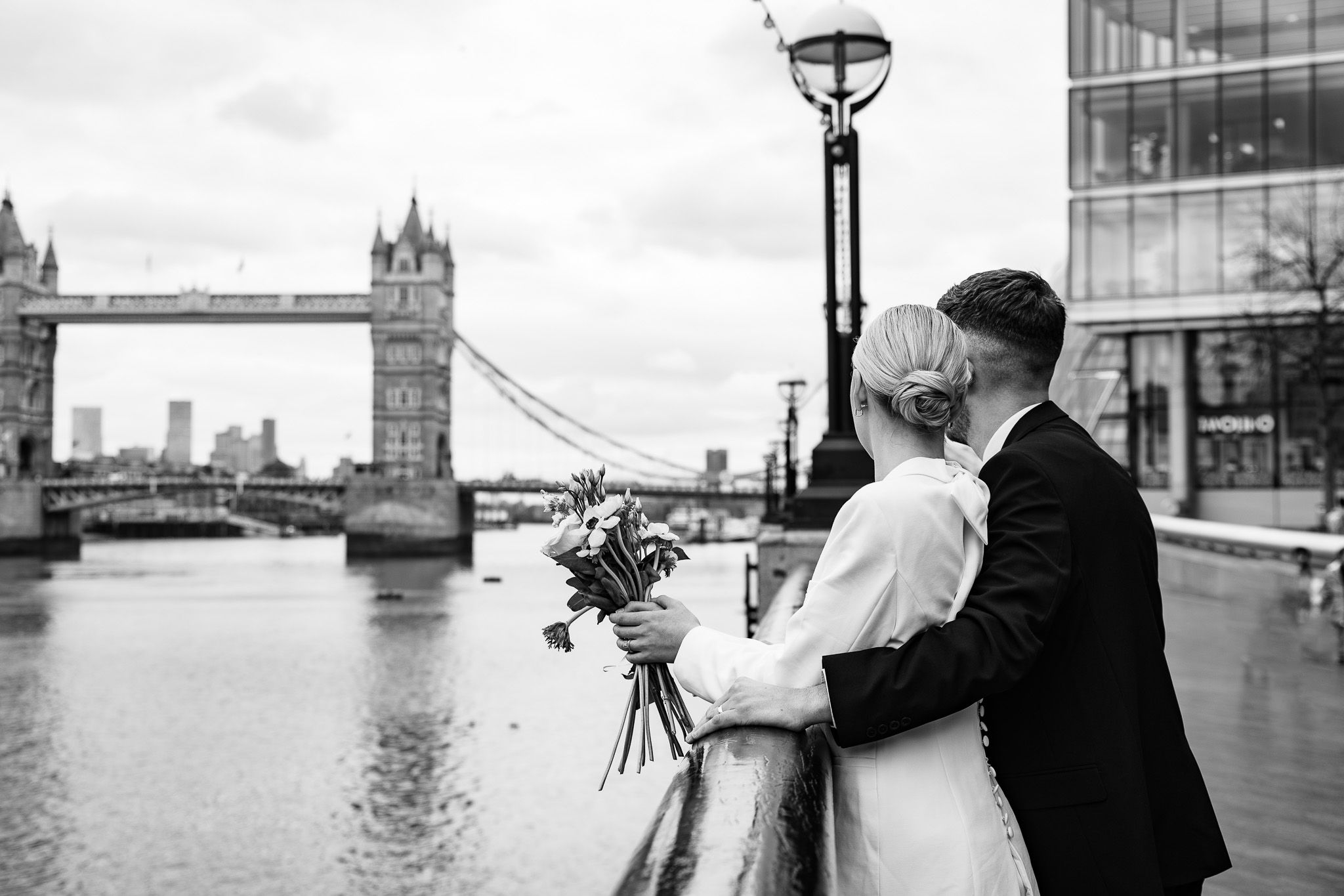 A series of romantic wedding photos captured at London's iconic Tower Bridge in black and white.
