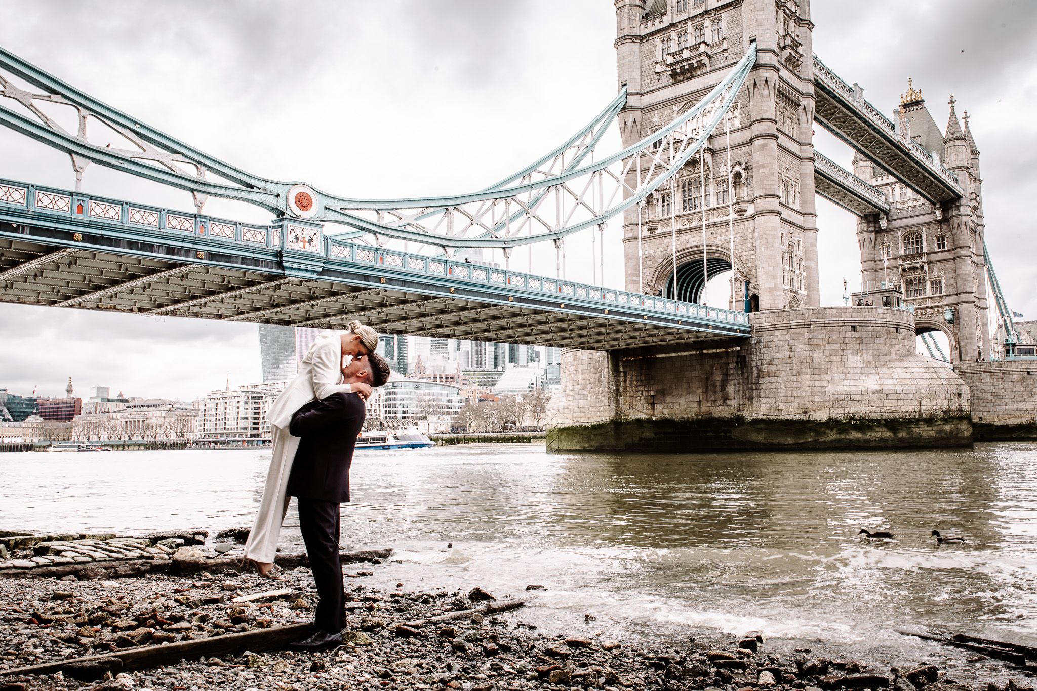 Wedding photography sequence showing romantic poses near Tower Bridge on a cloudy day.