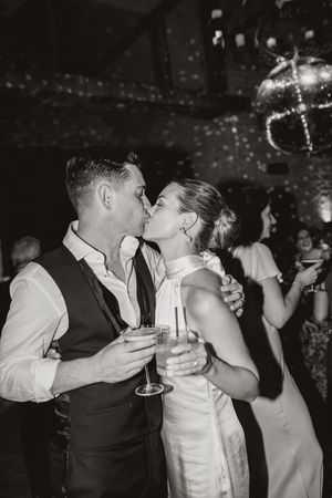 Wedding couple shares intimate dance moments at their reception in a dimly lit venue.