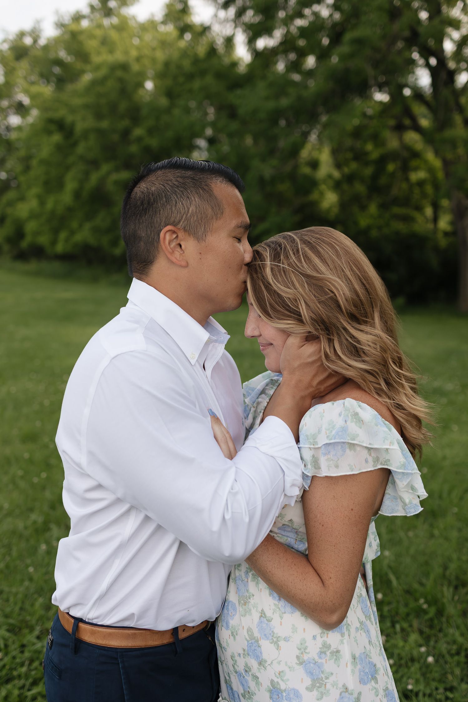 husband giving his wife a kiss on the forehead lovingly Family photographers kansas city