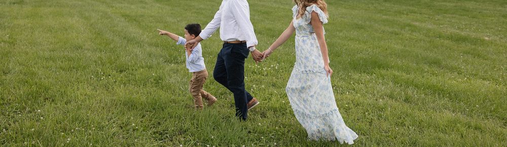 son leading parents through green grass