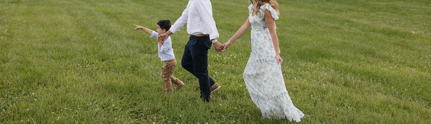 son leading parents through green grass