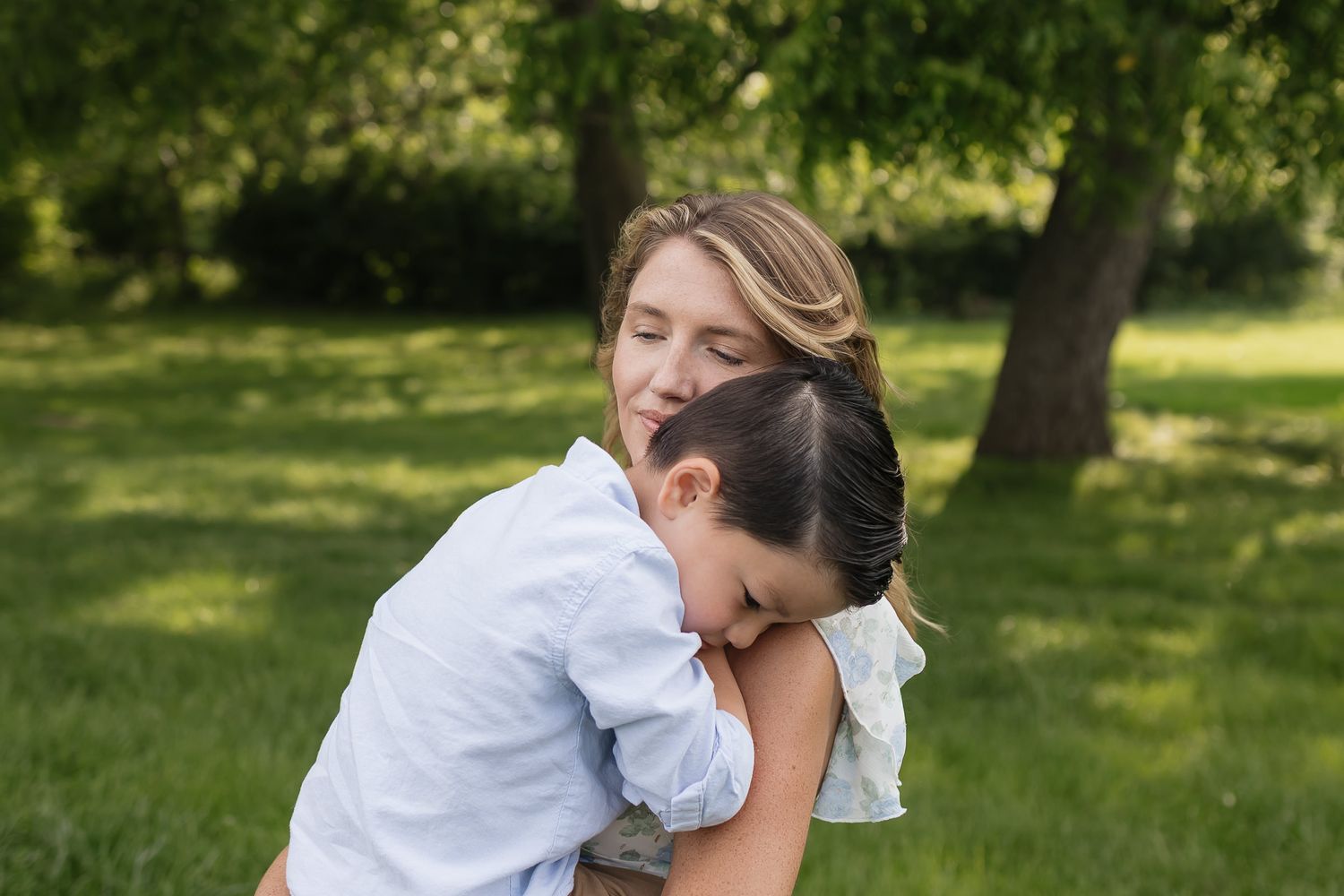 son snuggling on moms shoulder as she leans into his hug