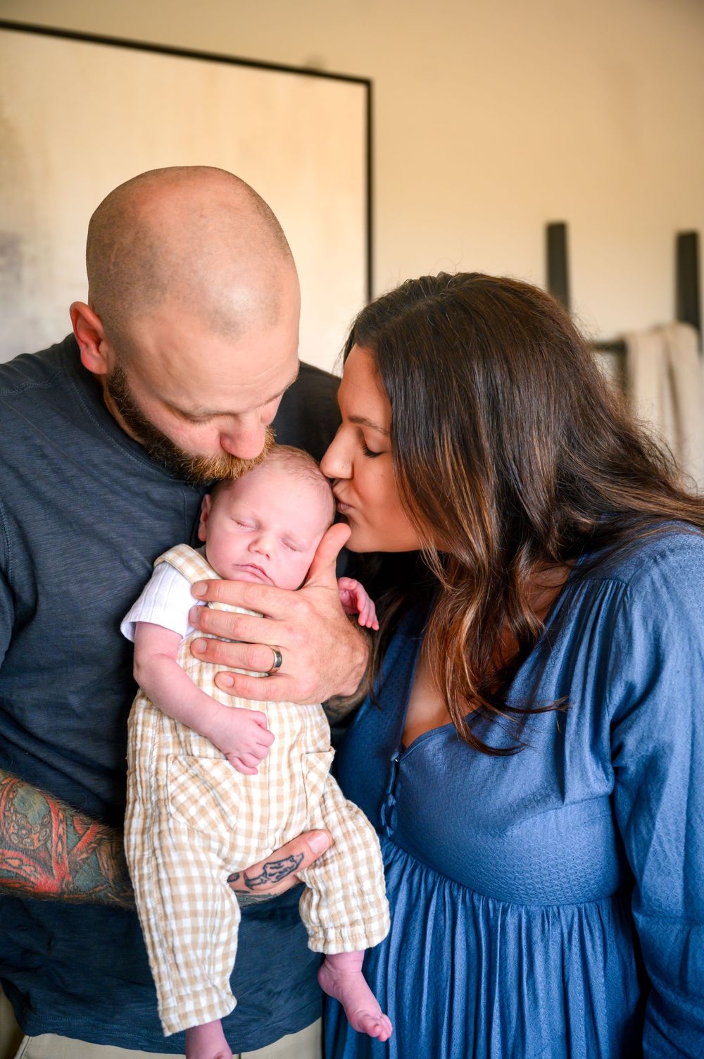 A series of tender family moments captured in sequence showing parents lovingly kissing their baby in a blue dress setting.