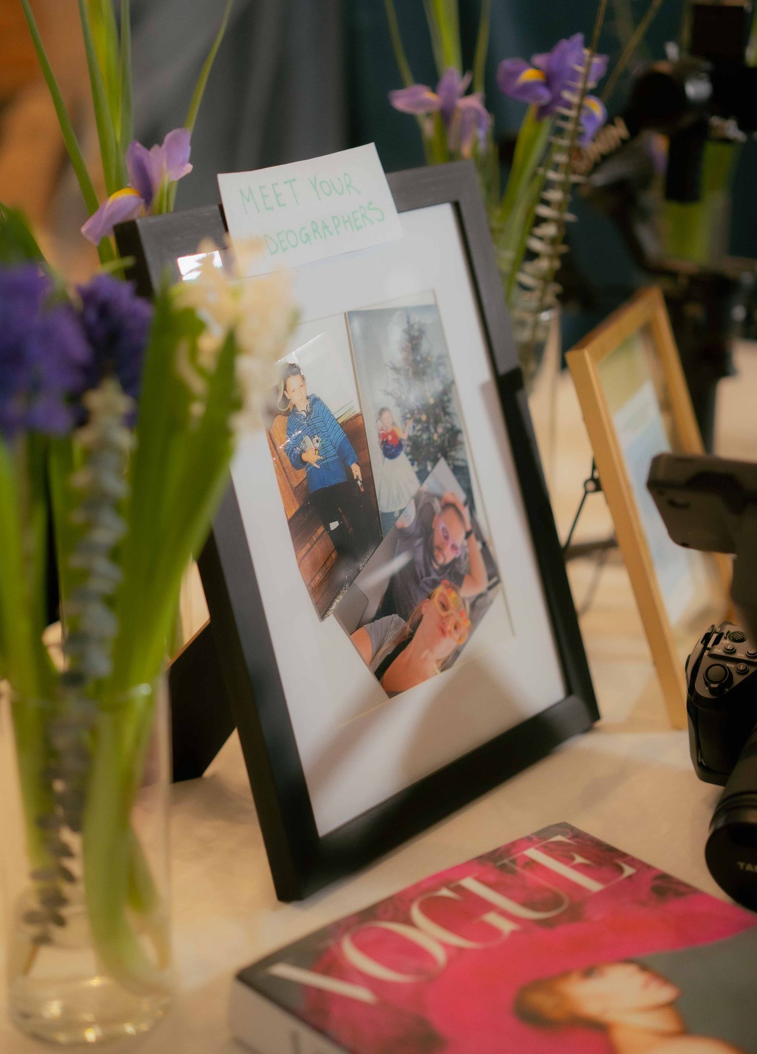 Framed photograph on display with purple flowers and magazine in foreground.