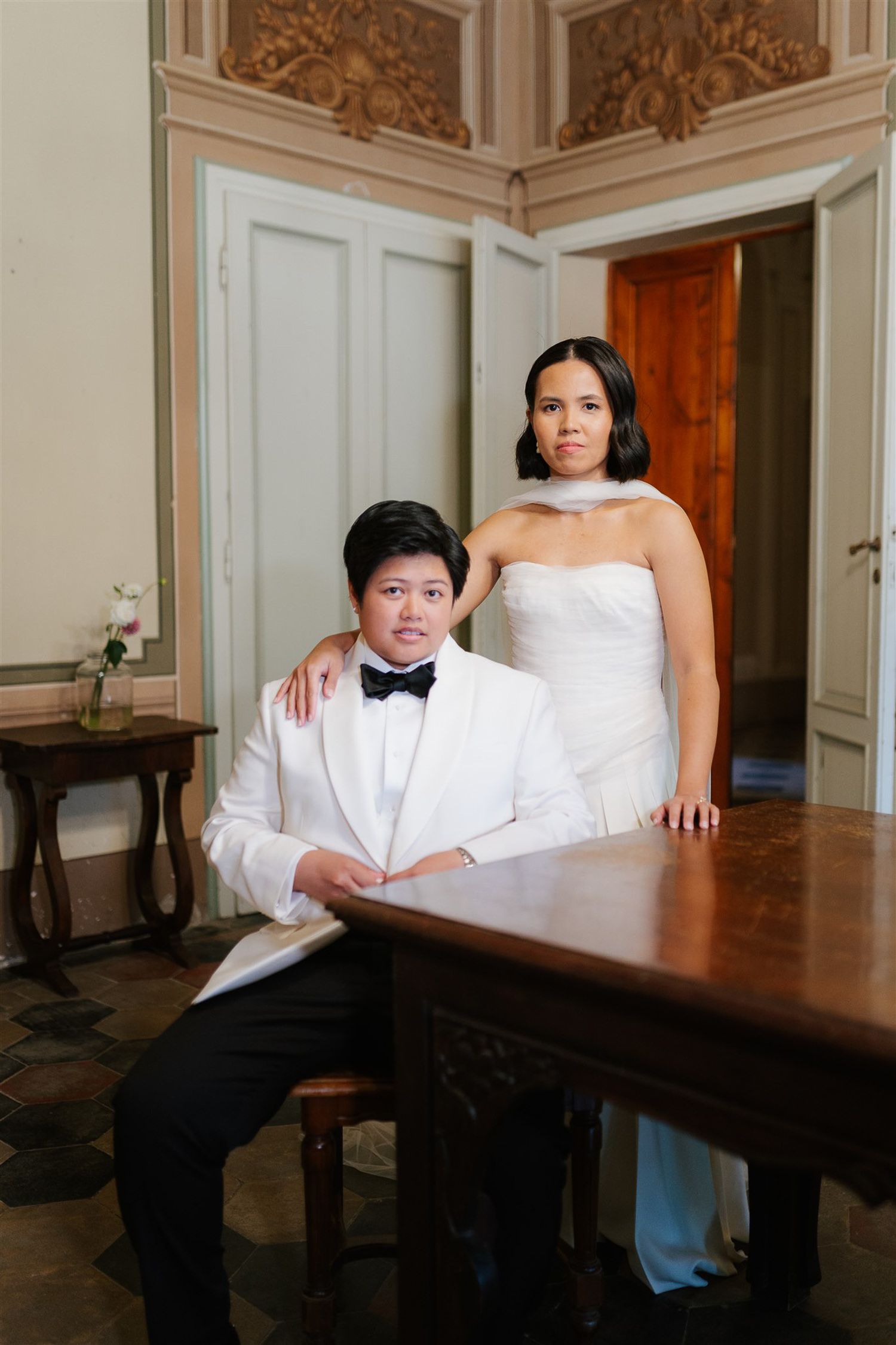 Elegant wedding portrait in a luxurious room with ornate moldings.