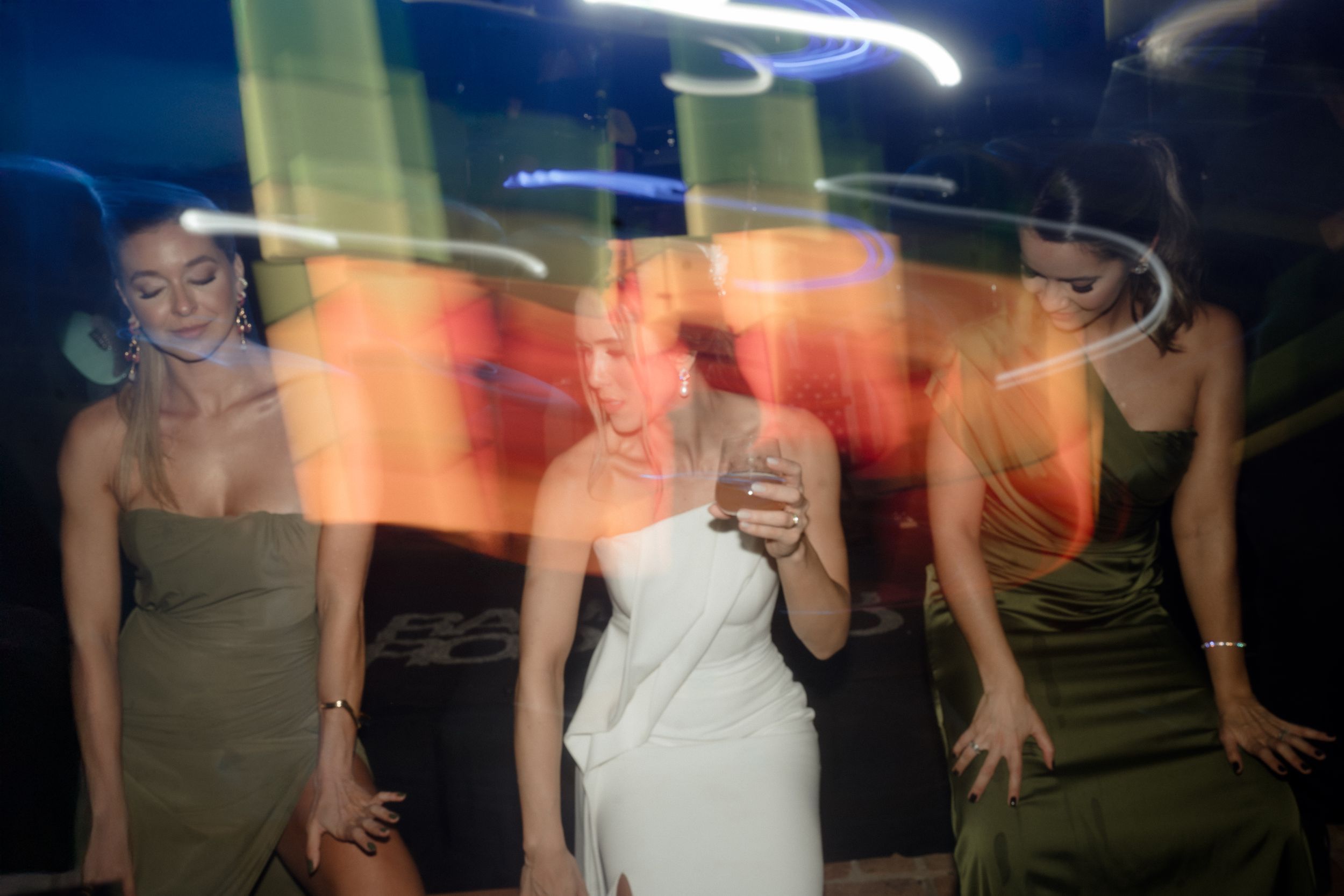 Long exposure shot captures dancing motion at party with blurred light trails.